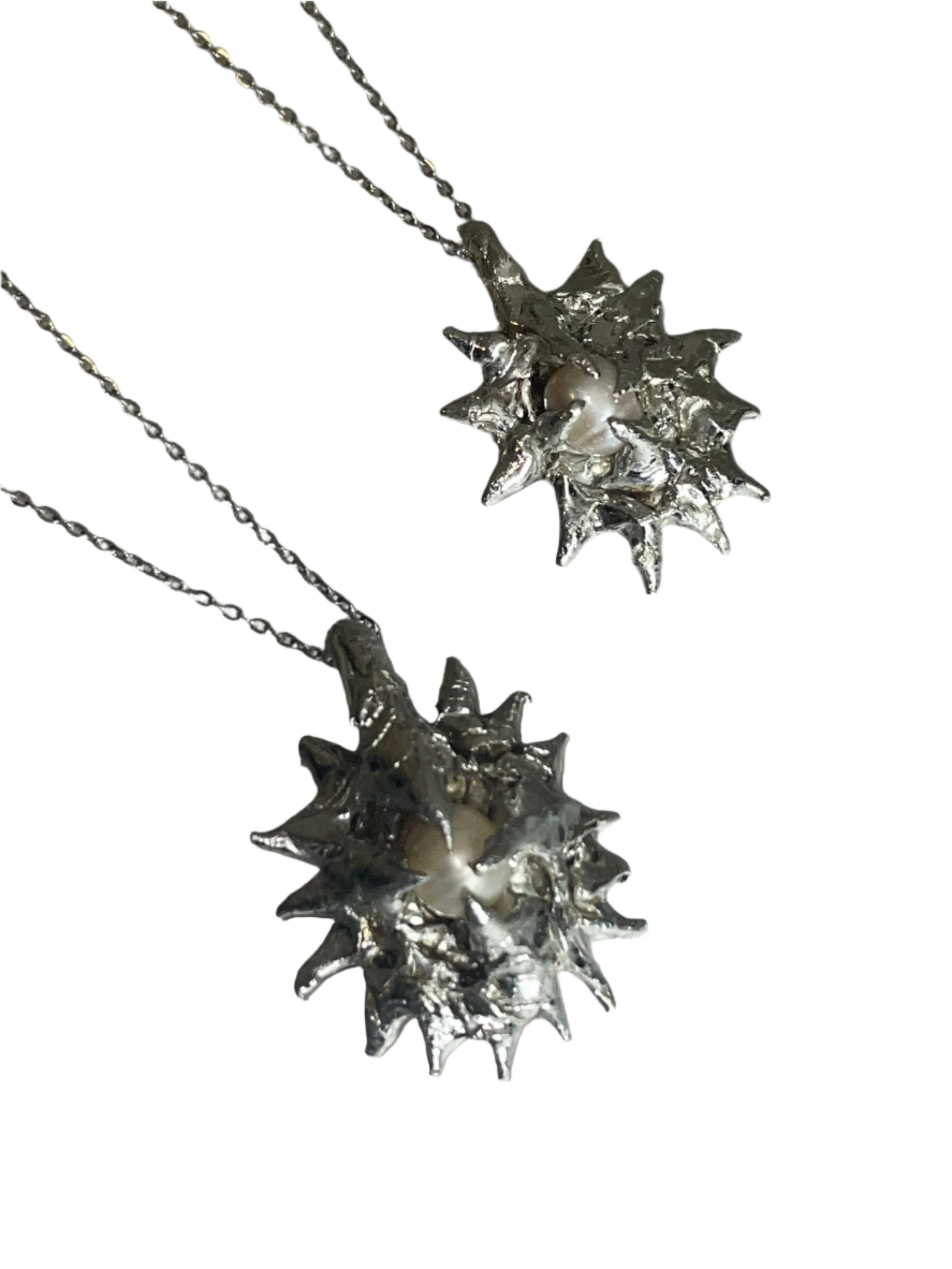 Silver star-shaped pendants on chains against a light gray background